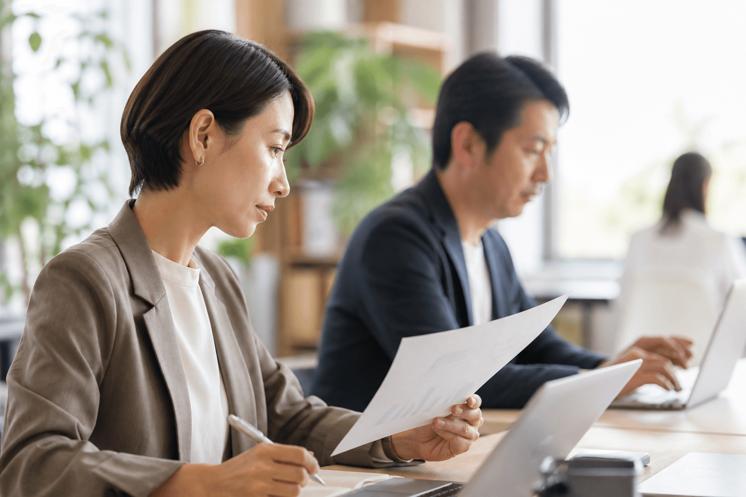 オフィスで真剣に仕事に向き合う働く人たち